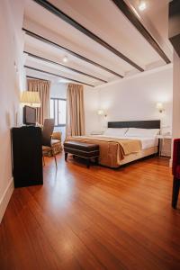 a large bedroom with a bed and a chair at YIT El Postigo in Úbeda