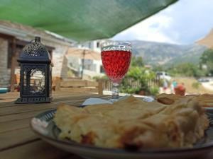 a plate of food and a glass of wine on a table at Agriogido - Rupicapra Villas in Papigko