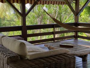 a porch with a hammock and a wooden table at Villa NO&LO in Sainte-Anne