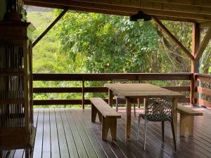a wooden table and bench on a wooden deck at Villa NO&LO in Sainte-Anne