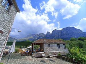 a building with a patio with mountains in the background at Agriogido - Rupicapra Villas in Papingo