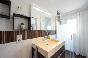 een badkamer met een wastafel en een spiegel bij Maison pour 6 entre Marais salants et plages in Les Bussolleries +18 foto's