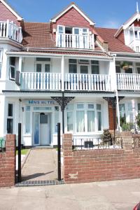 a white house with a brick fence in front of it at WNS Southend-on-Sea in Southend-on-Sea