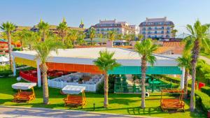 un edificio con palmeras y sillas delante de él en Crystal Family Resort & Spa - Ultimate All Inclusive, en Belek