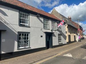 a white building with an american flag on a street at Remarkable 2-Bed Apartment in Norfolk Broads in Norwich