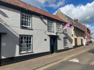 a white building with an american flag on a street at Stylish Historic Apartment - Sleeps 3 & Parking in Norwich