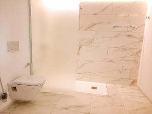 a white bathroom with a shower and a toilet at Termas Romanas Allon by Seaward Suites in Villajoyosa