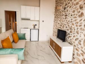 a living room with a couch and a tv at Termas Romanas Allon by Seaward Suites in Villajoyosa