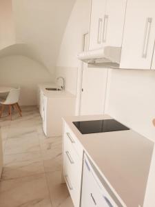 a white kitchen with a sink and white cabinets at Termas by Seaward Suites in Villajoyosa