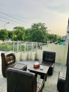 a patio with two couches and a coffee table at HOTEL ROSE INN in Lahore