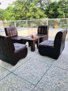 three chairs and a table and a table and chairs at Hotel Rose Inn Lahore in Lahore +20 photos