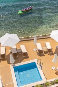 a swimming pool with chairs and umbrellas next to the ocean at Greek Beach House Complex B4 in Nydri +7 photos