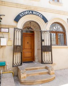 een toegang tot een hotel met een houten deur en trap bij Utopia Hotel Baku in Baku