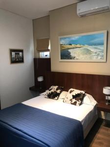 sypialnia z łóżkiem z niebieskim kocem i poduszkami w obiekcie Habitaciones en Suite Balcarce w BuenosAires