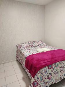 um quarto com uma cama com um cobertor roxo em APTO ACONCHEGANTE a 10 minutos da praia do aracagir ,prox de de shopping,parque aquatico,lanchonetes,farmácias em São Luís