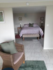 a bedroom with a bed and a couch and a chair at Les érables in Saint-Sulpice-les-Feuilles