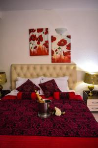 a bedroom with a bed with a red comforter with a bowl on top at Villa Bella Boutique Hotel in Kavadarci