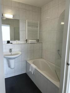 a white bathroom with a tub and a sink at Van der Valk Hotel De Molenhoek-Nijmegen in Molenhoek +25 photos
