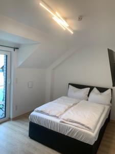 a bed in a room with a white wall at AT-Rooms in Hannover