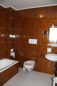 La salle de bains est pourvue de toilettes, d'une baignoire et d'un lavabo. dans l'établissement Alpina Mountain Resort, à Sulden