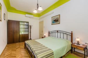 a bedroom with a large bed and a wooden floor at Apartment Juna in Rijeka