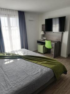 Schlafzimmer mit einem Bett, einem Schreibtisch und einem TV in der Unterkunft Villa Katzenbuckel in Waldbrunn