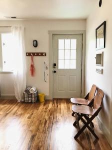 a living room with a chair and a door at Cottage by the Sea: Pagnotto Shellback House in Oak Island