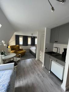 ein Zimmer mit einer Küche und einem Wohnzimmer mit einem Bett in der Unterkunft Ferienhaus Wiethüchter in Lübeck