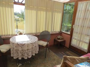 a room with a table and chairs and windows at The Smithy in Snettisham