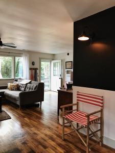 uma sala de estar com um sofá e uma cadeira em Cottage by the Sea: Pagnotto Shellback House em Oak Island