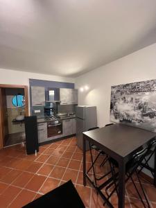 una cucina con tavolo e una cucina con frigorifero di Motel Del Grosso a Eboli