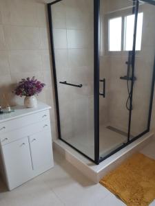 a shower with a glass door in a bathroom at Monte das Flores Casa de Campo 