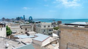 Blick auf eine Stadt mit Gebäuden und das Meer in der Unterkunft Utopia Hotel Baku in Baku