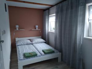 a small bedroom with a bed with two green bags on it at Domek na Prerii in Ustrzyki Dolne