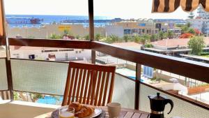 a table with a plate of pastries on a balcony at Vistas al mar Jardines Canarios Los Cristianos in Los Cristianos