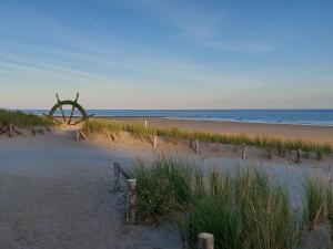 una spiaggia sabbiosa con una scultura sulla spiaggia di Apartment Noordhinder Westende a Middelkerke Altre 13 foto