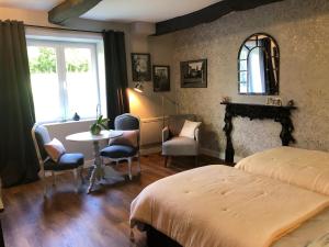 a bedroom with a bed and a table and a window at Val du Lys in Sainte-Maure-de-Peyriac