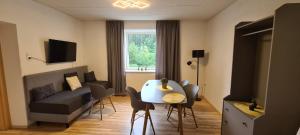 a living room with a table and a couch at Apartments Laura in Oberweg