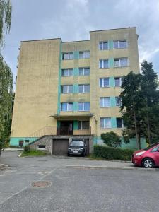 a large building with cars parked in front of it at Apartamenty Nadrzeczna 14 in Karpacz