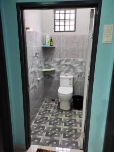 een badkamer met een toilet en een tegelvloer bij Homestay Salak 756 at Sungai Siput Kuala Kangsar for Islamic Guest Only in Sungei Siput