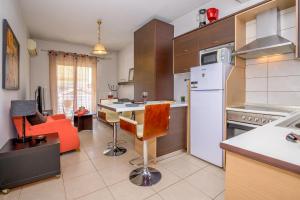 uma cozinha com um frigorífico branco e uma mesa com cadeiras em cozy panta em Orestias
