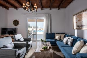 uma sala de estar com um sofá azul e cadeiras em Filothei Beach House with pool em Kalamaki