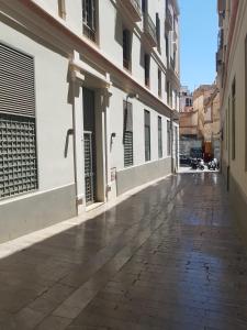 an empty street in a city with white buildings at Apartamento Plaza del Teatro Parking free in Málaga