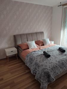 Un dormitorio con una cama grande con almohadas. en Dévai-LUX Apartman Sárvár, en Sárvár