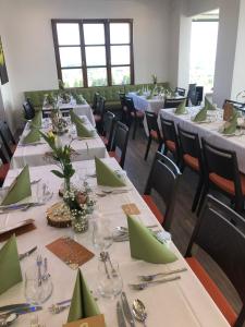 ein Zimmer mit langen Tischen und Stühlen mit grünen Servietten in der Unterkunft Villa Katzenbuckel in Waldbrunn