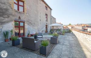 a patio with potted plants on the side of a building at La maison des archers in Saint-Saturnin