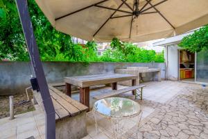 Eine Terrasse mit zwei Bänken und einem Sonnenschirm in der Unterkunft cozy panta in Orestiada