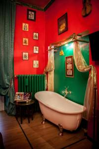 a bath tub in a room with red and green walls at Repubblica Di Oz in Varese +34 photos