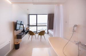 a bathroom with a sink and a table with chairs at Le Nautica Hôtel in Perros-Guirec