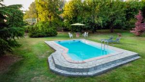 - une piscine dans une cour avec des chaises et une table dans l'établissement Il Principe rosso, à Roatto